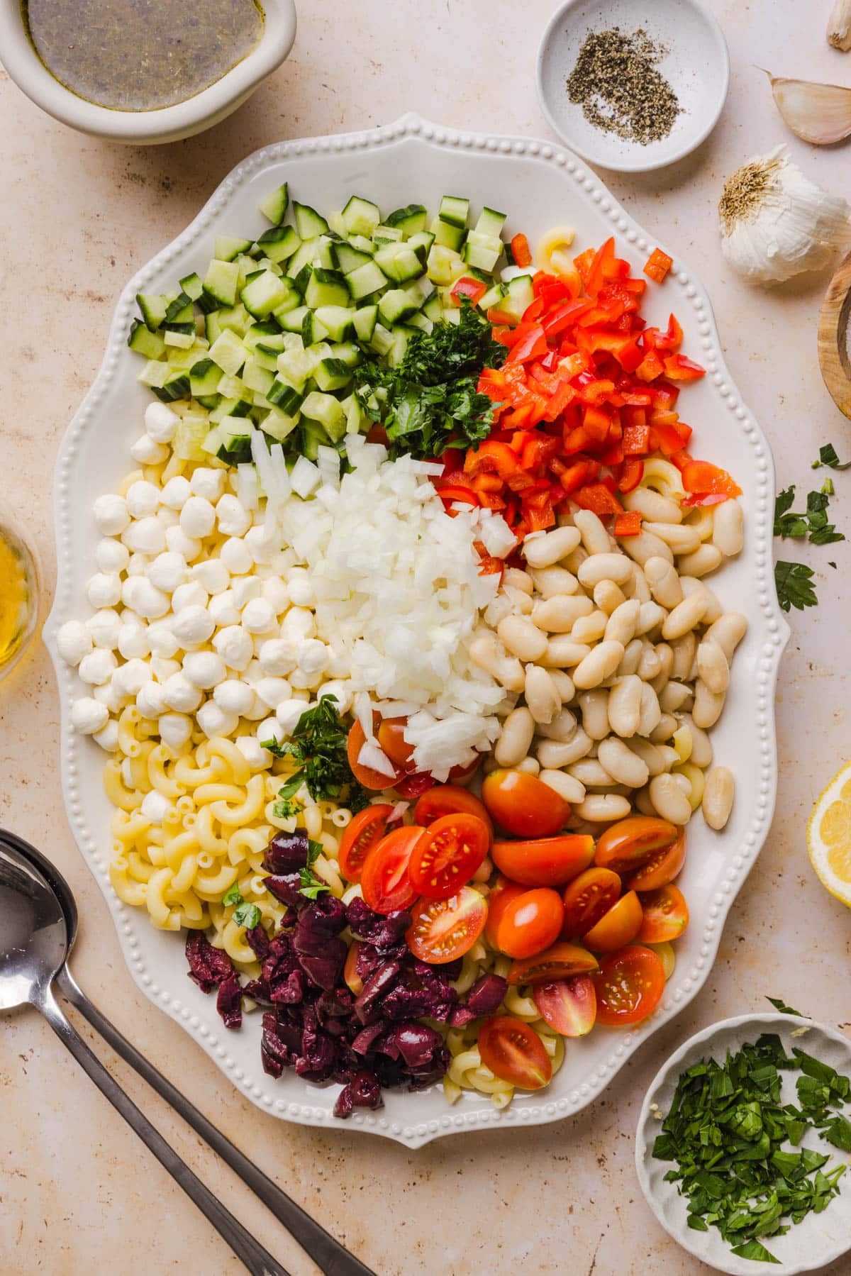 All of the ingredients for the salad except for the dressing on an oval serving platter on a countertop.