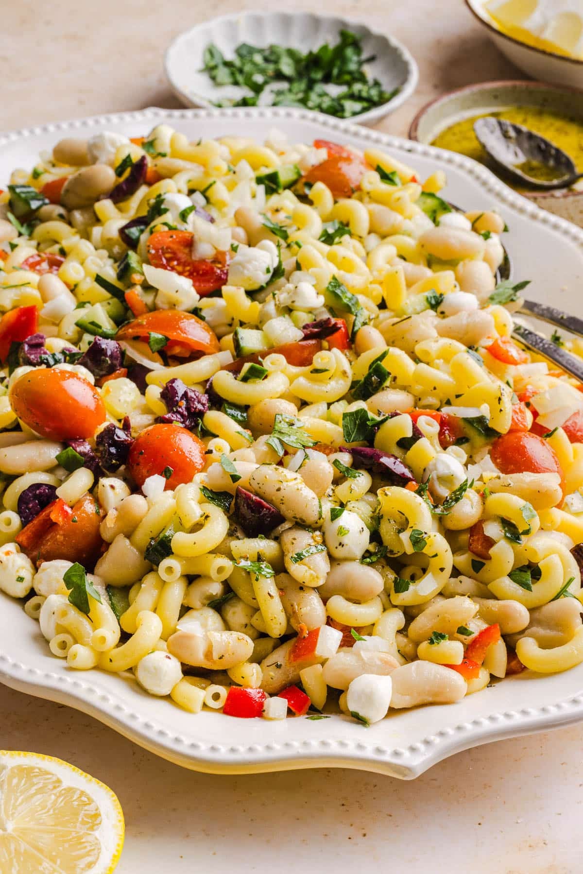 Pasta and bean salad on a white serving platter on a countertop.