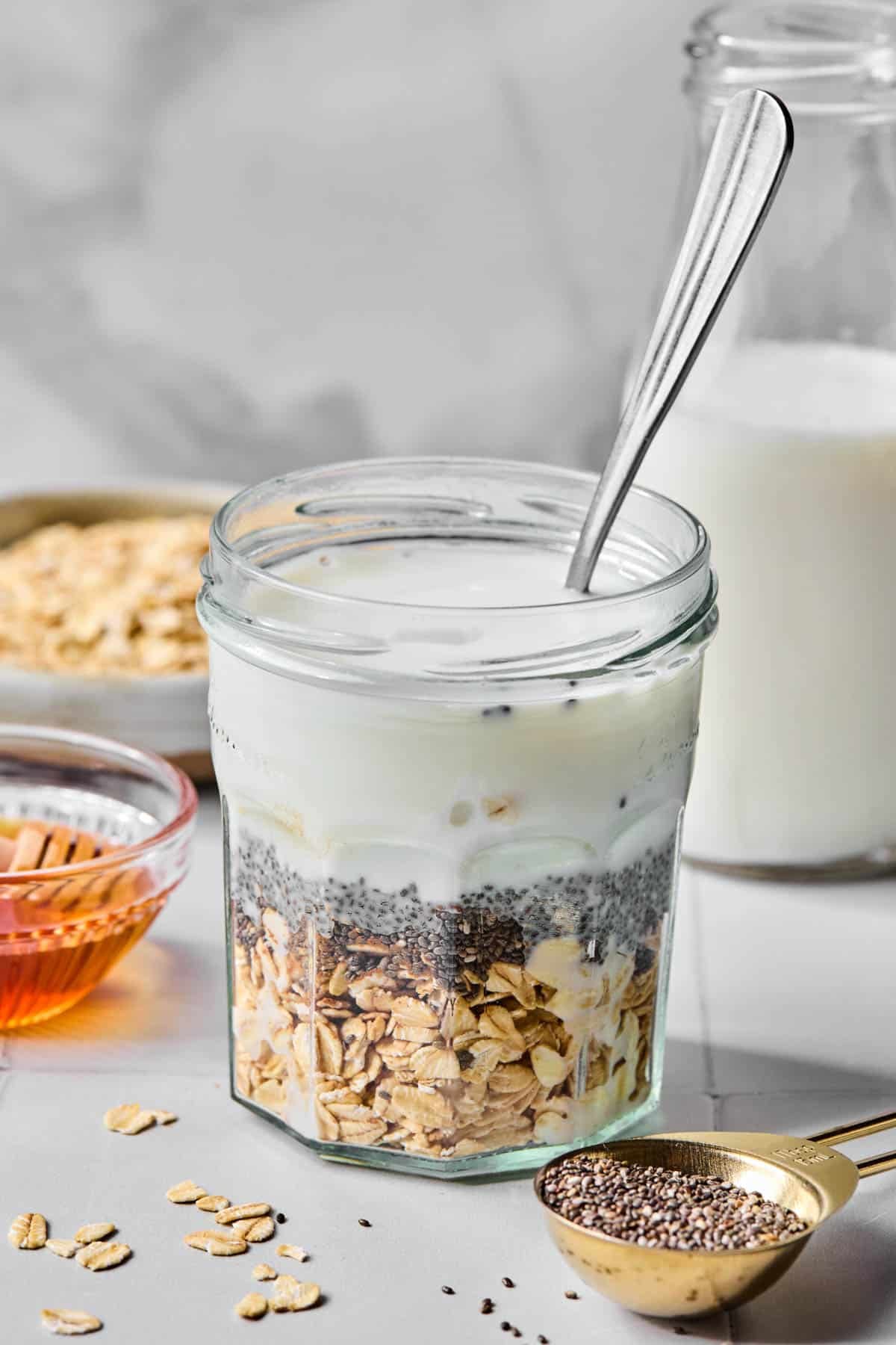 All of the ingredients for vanilla overnight oats in a jar before stirring.
