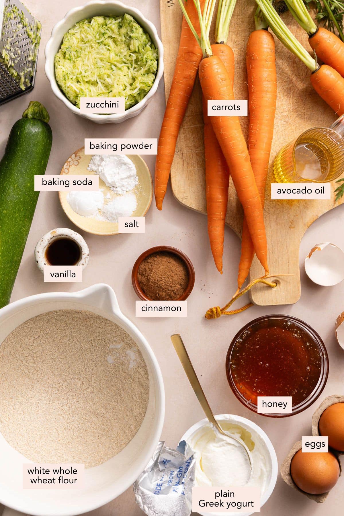 All of the ingredients for zucchini carrot bread in bowls on a countertop.