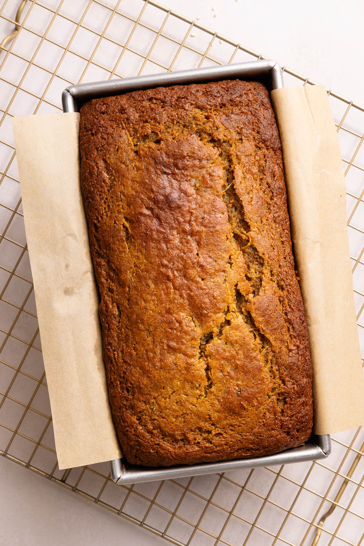The bread in the pan on a cooling rack after baking in the oven.