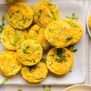 Zucchini Egg Muffins with cottage cheese on a white serving platter on a countertop.