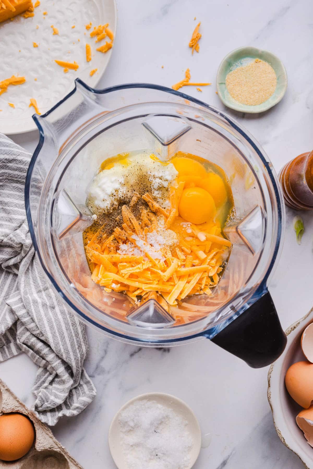The eggs, cottage cheese, cheddar cheese, salt and pepper in a high speed blender before blending.