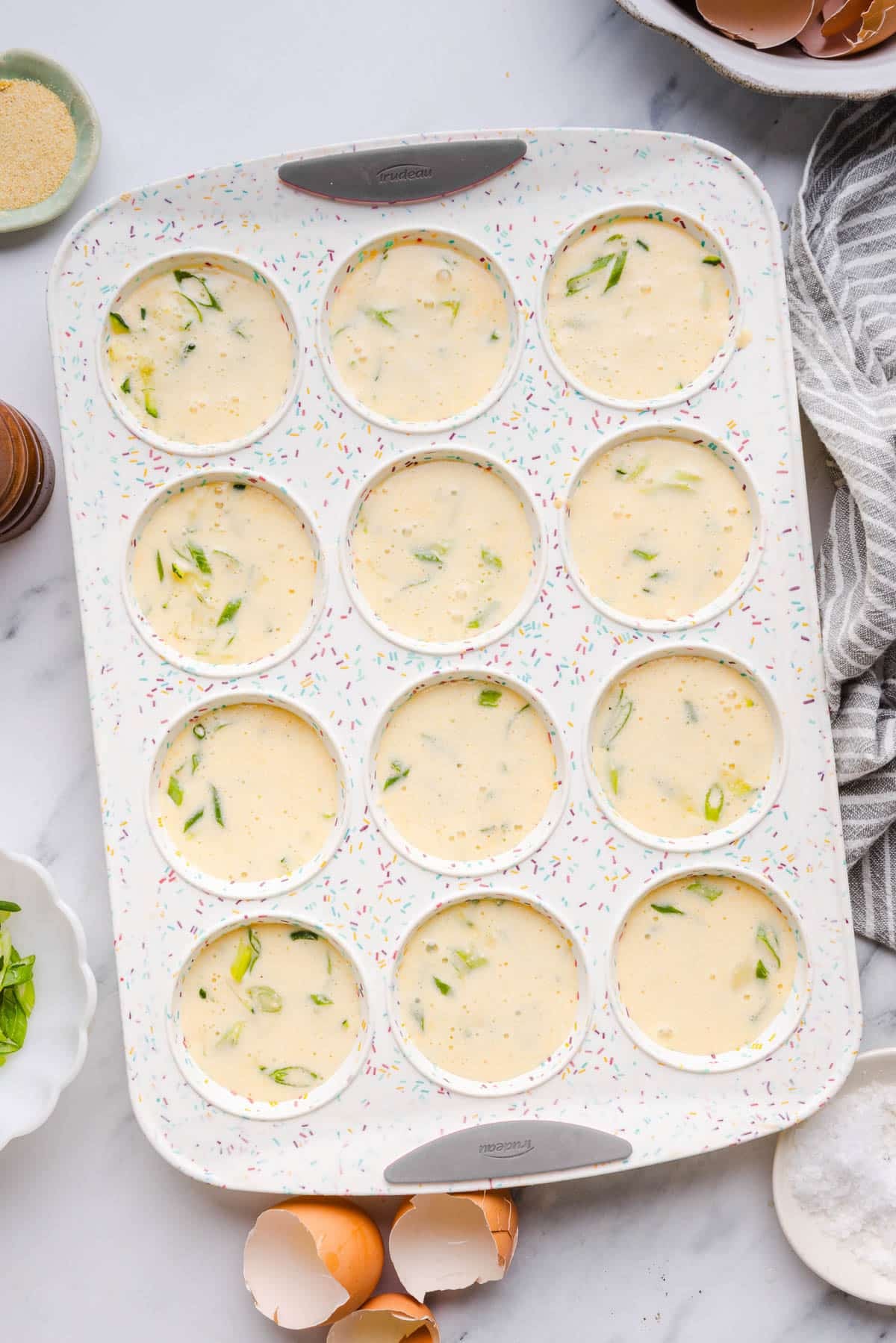 The egg mixture poured in the muffin tin.