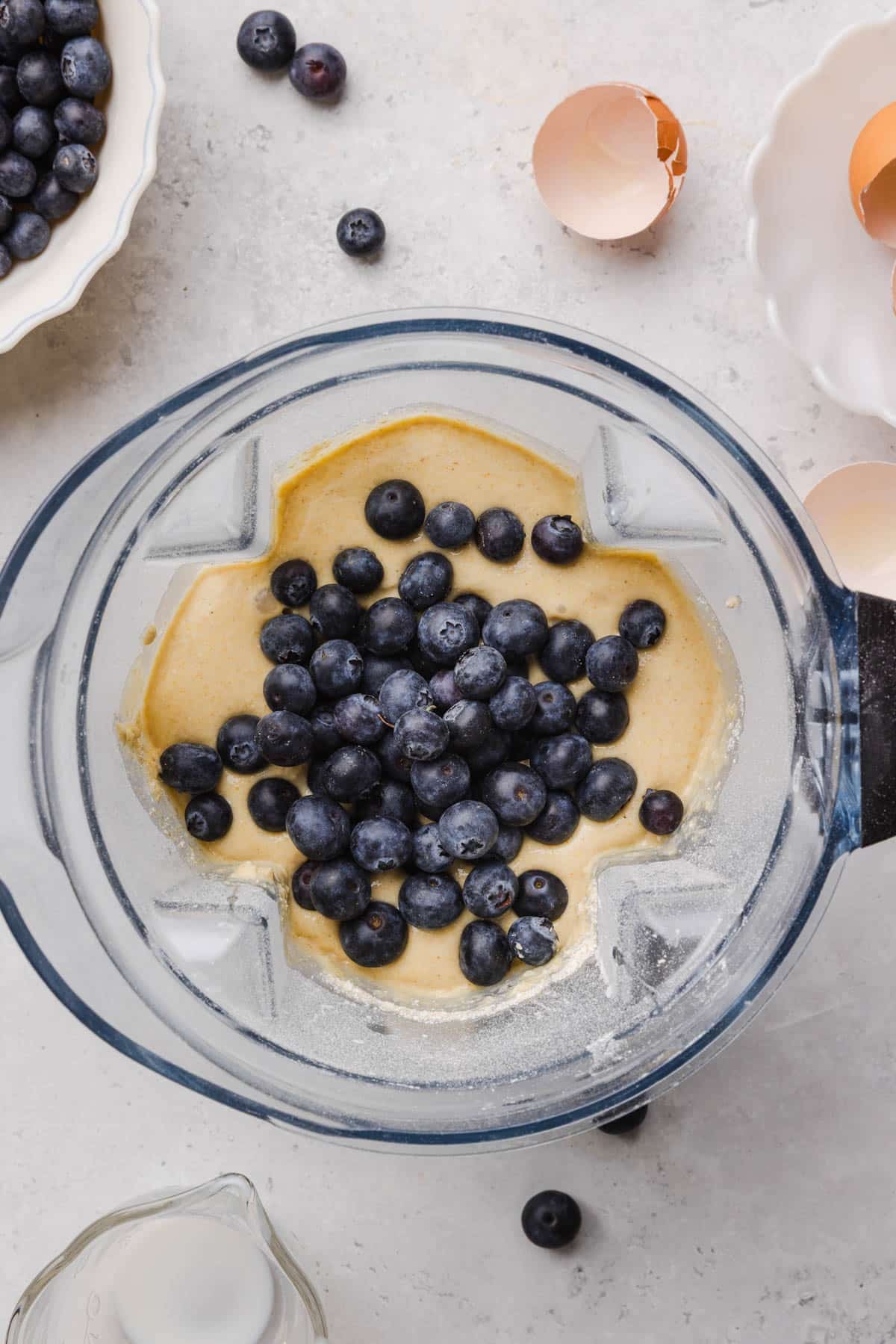 The blueberries on top of the batter in the blender before stirring in.