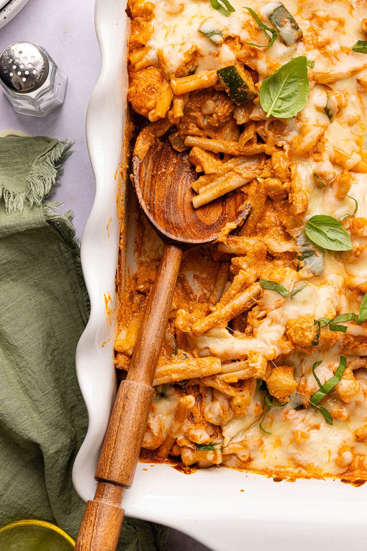 A spoon scoops the cottage cheese pasta bake from the baking dish.