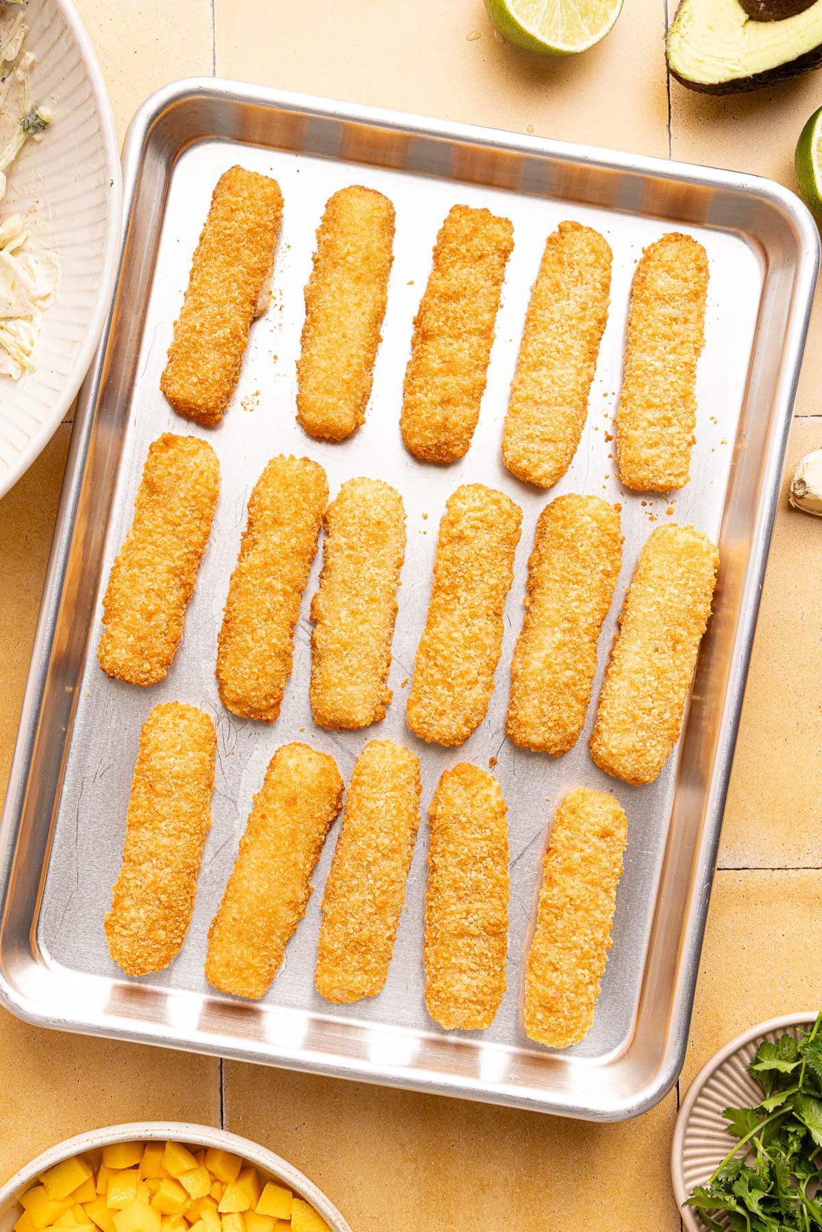 The fish sticks on the baking pan after cooking.