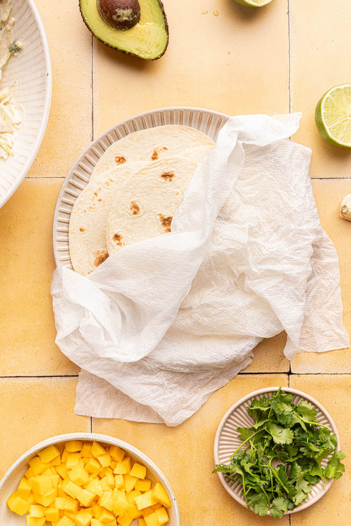 The warm tortillas on a white plate.