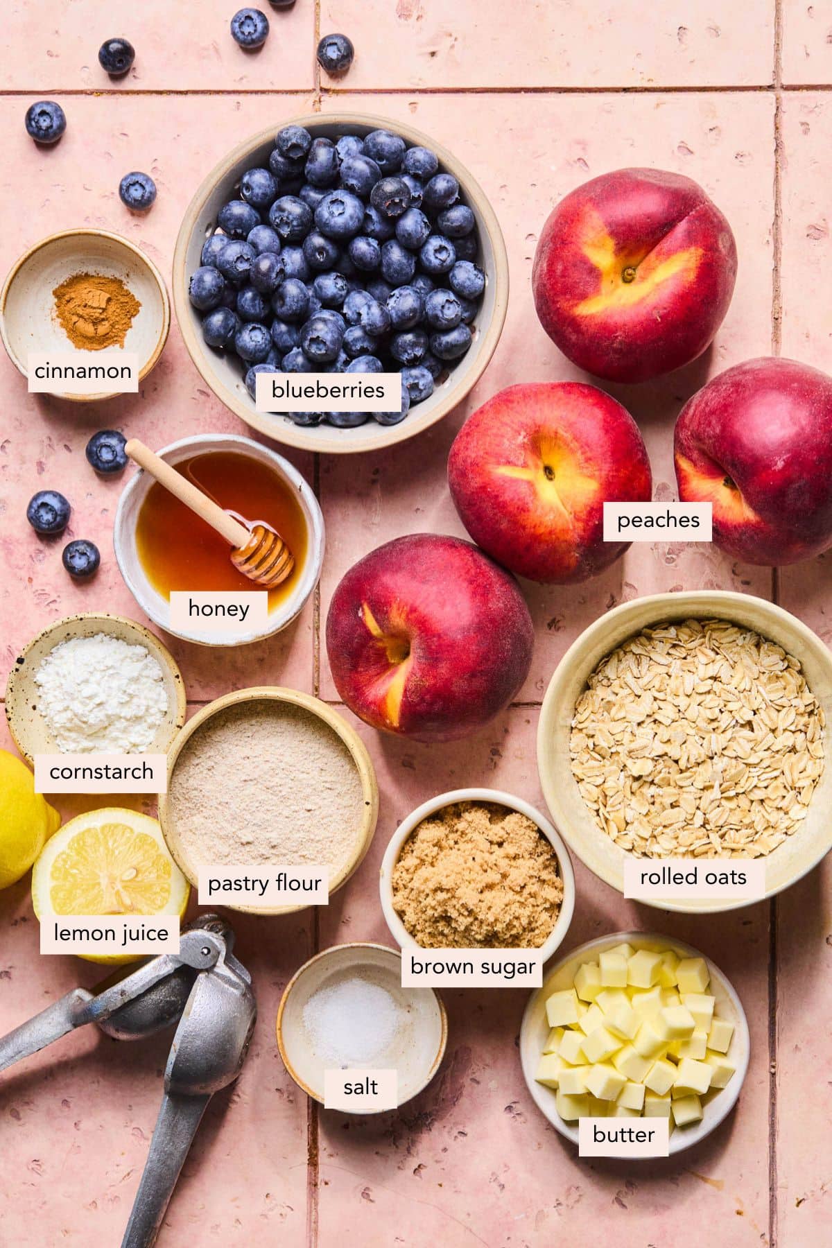 All of the ingredients for peach blueberry crumble in bowls on a countertop.