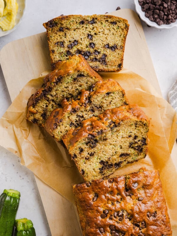 Slices protein zucchini bread on a piece of parchment paper on a countertop.