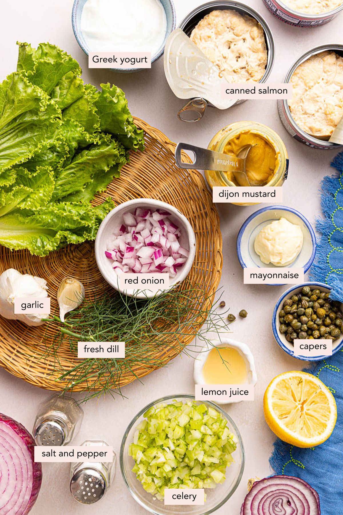 All of the ingredients for salmon salad sandwich in bowls on a countertop.