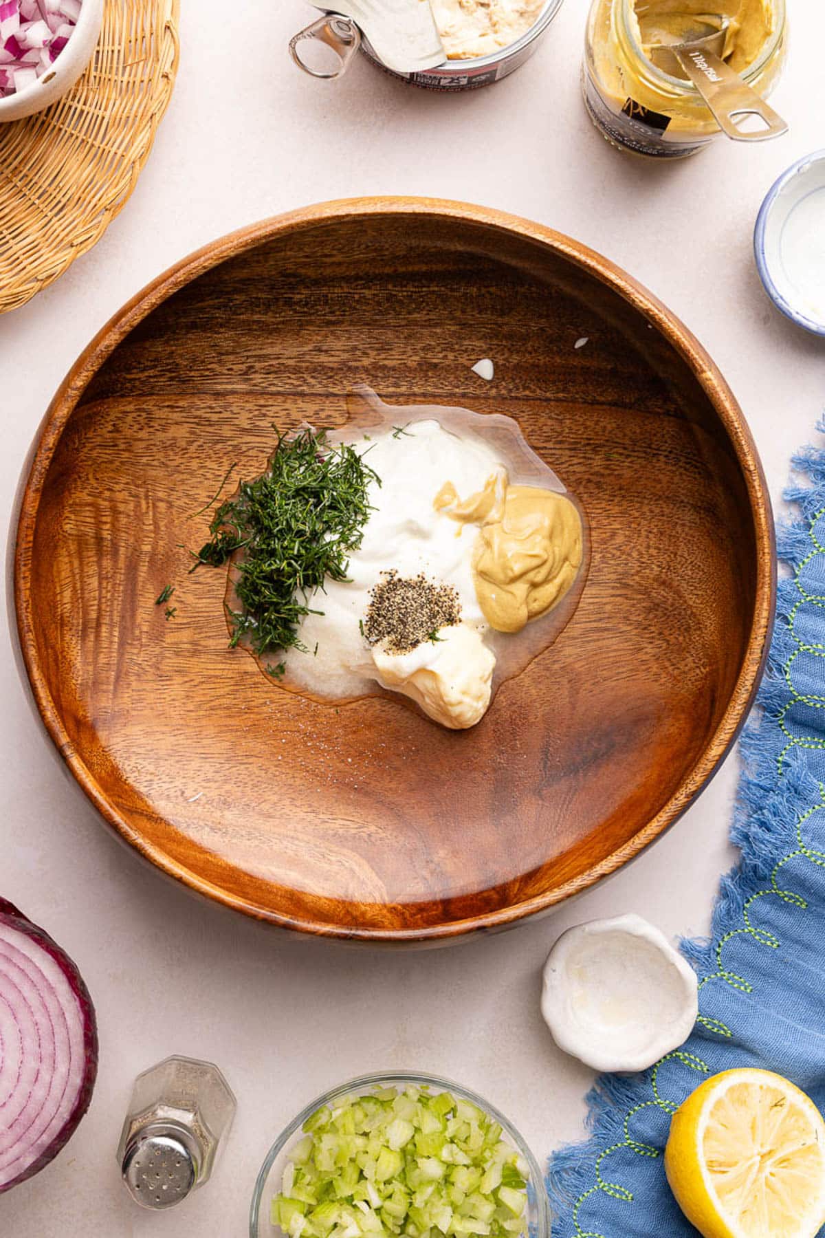 The greek yogurt, mayo, mustard, lemon juice, garlic, dill, and pepper in a bowl before mixing together.