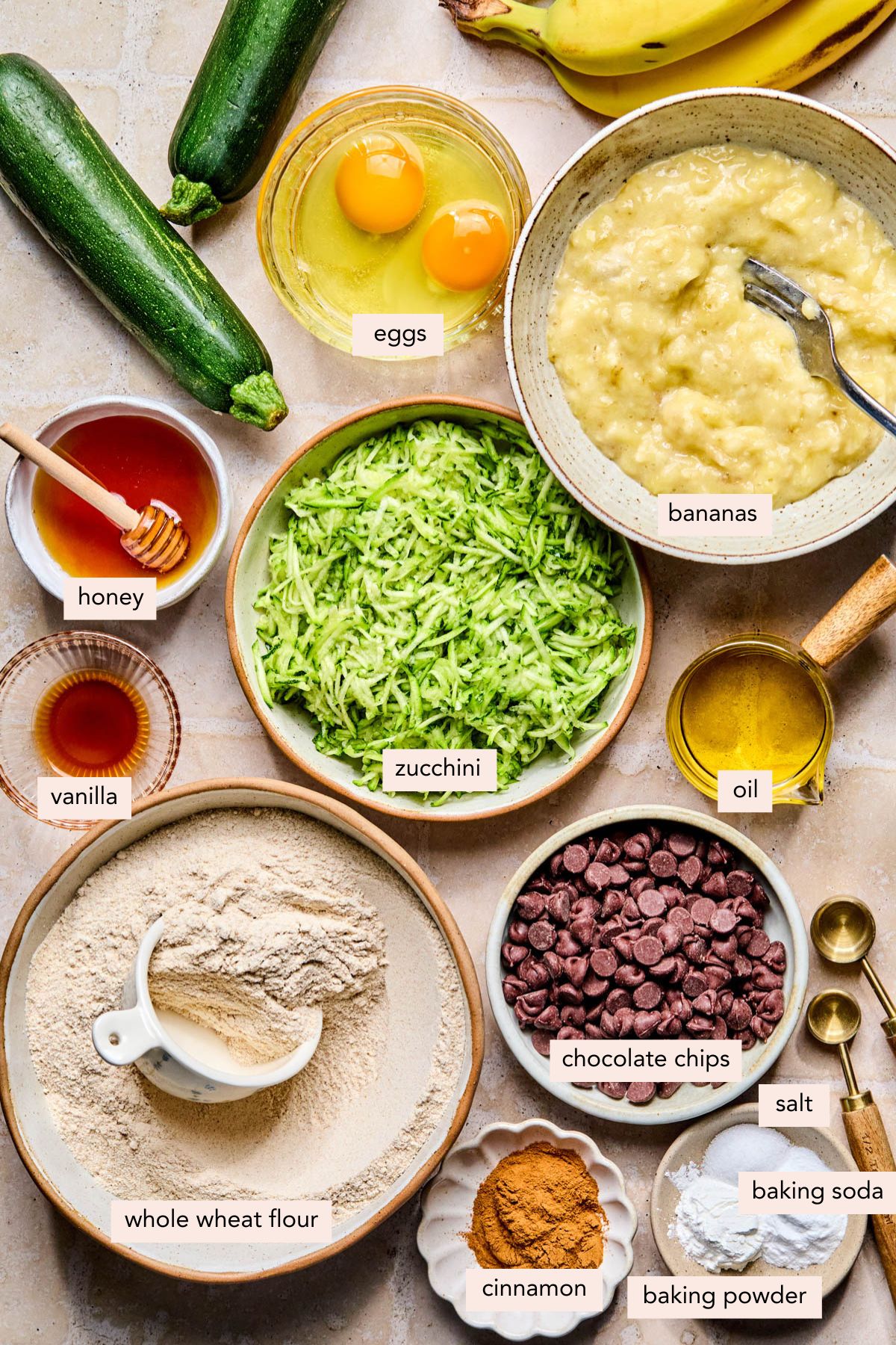 All of the ingredients for zucchini banana bread with chocolate chips on a countertop.