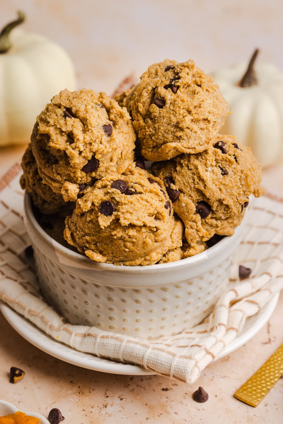 Edible pumpkin cookie dough scoops in a small bowl.