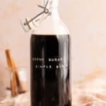 A bottle filled with brown sugar simple syrup on a countertop.