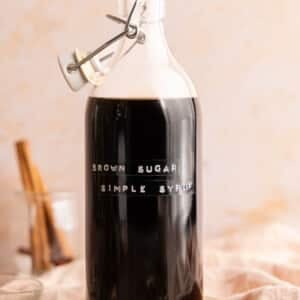 A bottle filled with brown sugar simple syrup on a countertop.