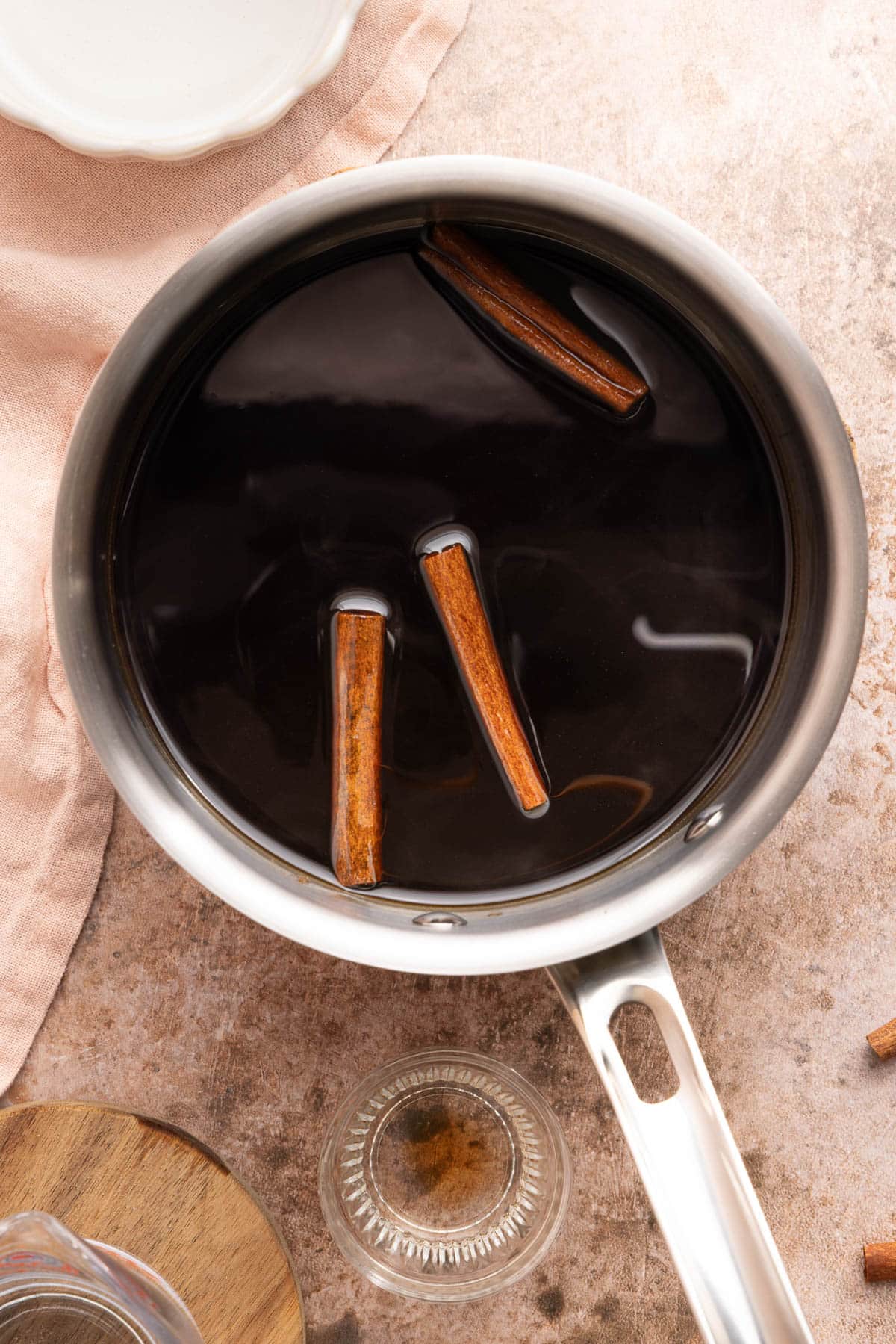 The brown sugar mixture in the pan with the cinnamon sticks.