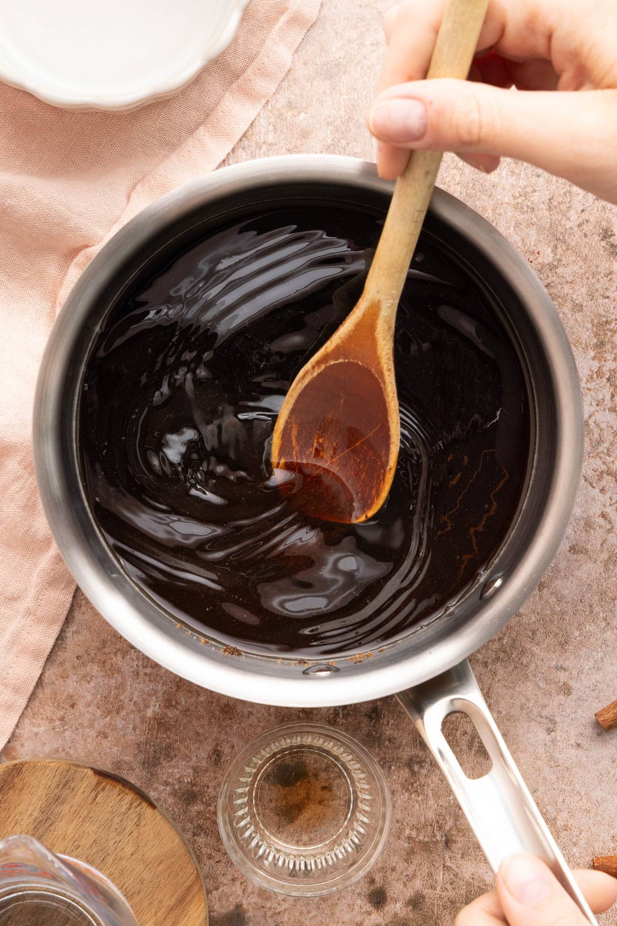 The water and brown sugar in a pan with a spoon.