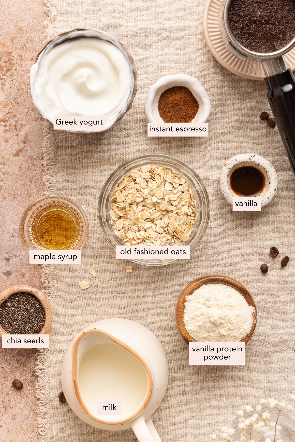 All of the ingredients for coffee overnight oats in bowls on a countertop.