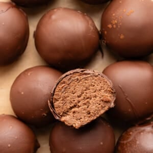 A cut cottage cheese truffle sits on top of a stack of remaining cottage cheese truffles.