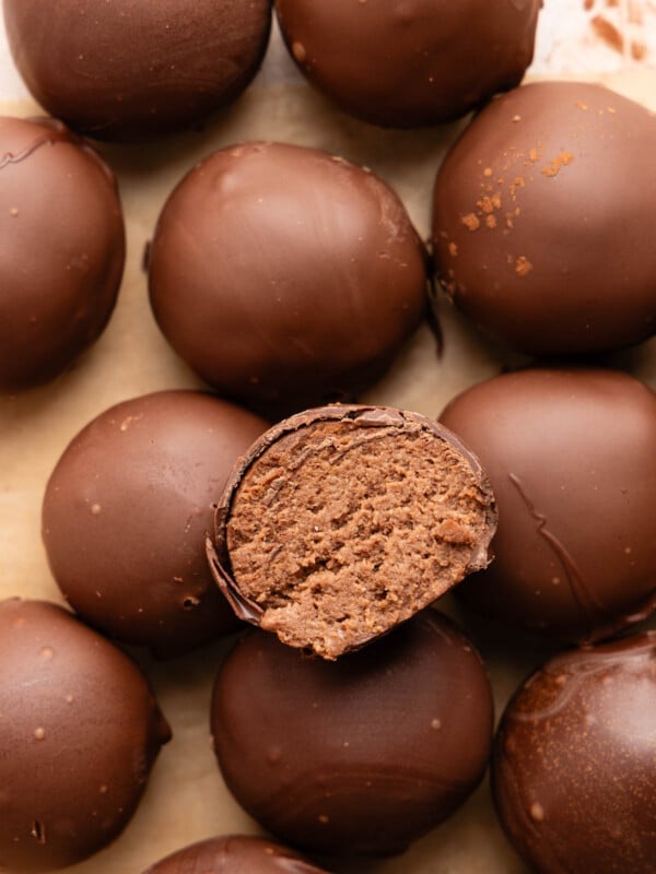 A cut cottage cheese truffle sits on top of a stack of remaining cottage cheese truffles.