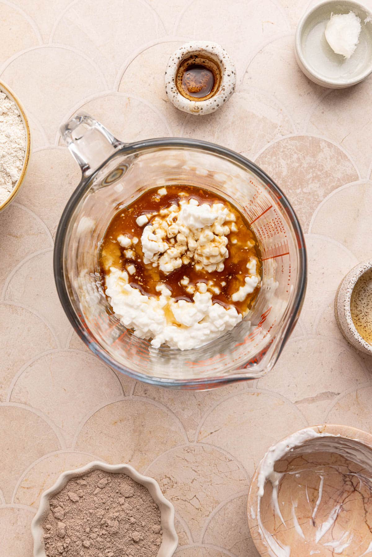 Cottage cheese, maple syrup and vanilla in a glass measuring cup before blending.