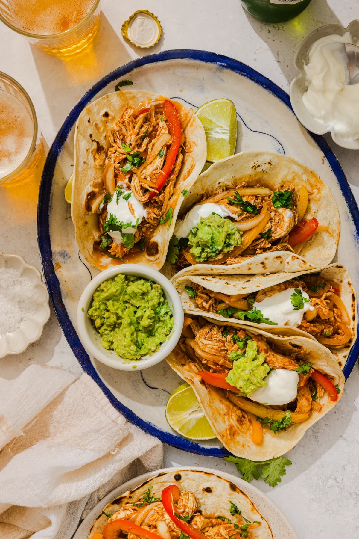 Chicken fajitas sitting on a large oval platter on a countertop.