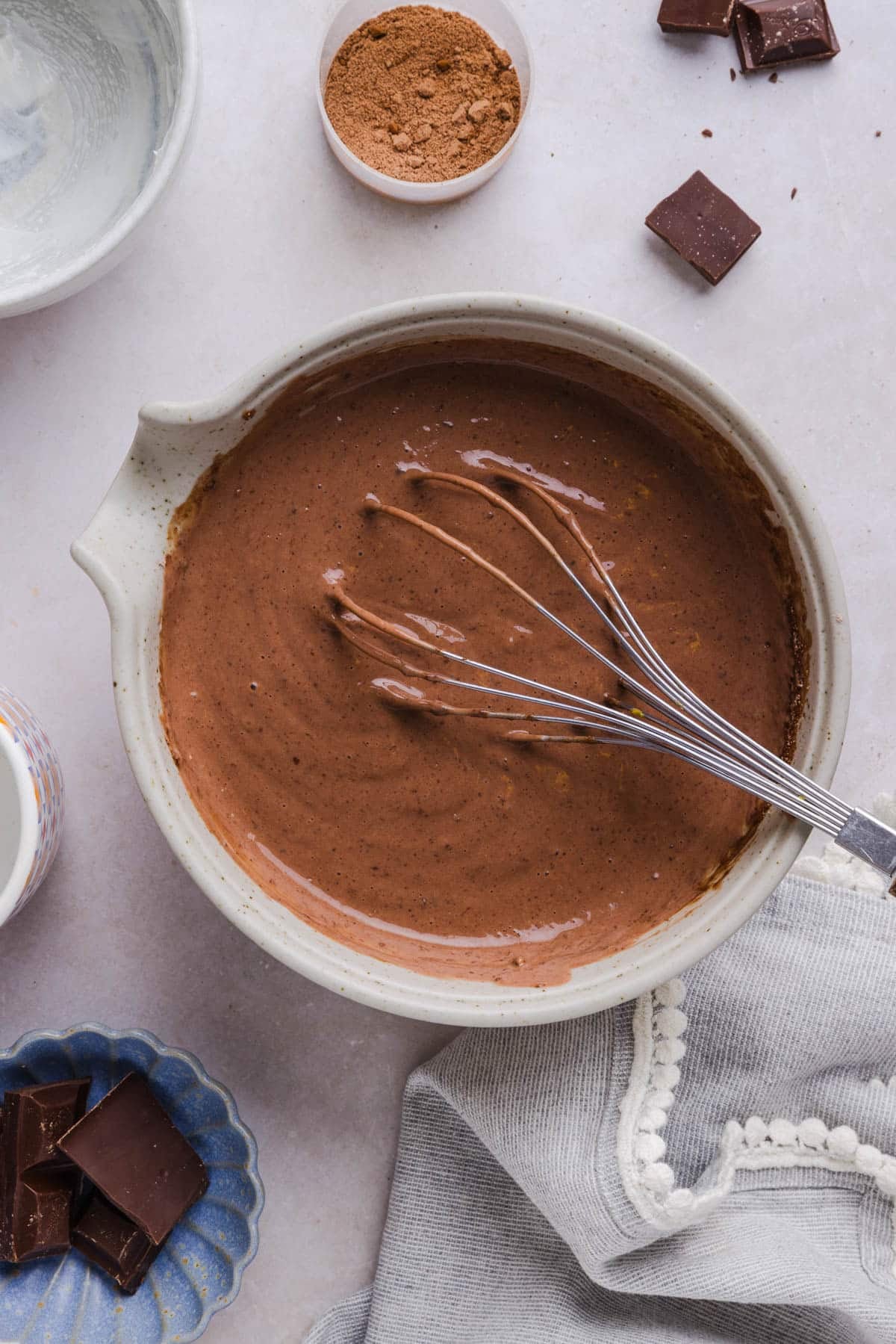 The chocolate protein pudding mixture combined with a whisk in the bowl on a countertop.