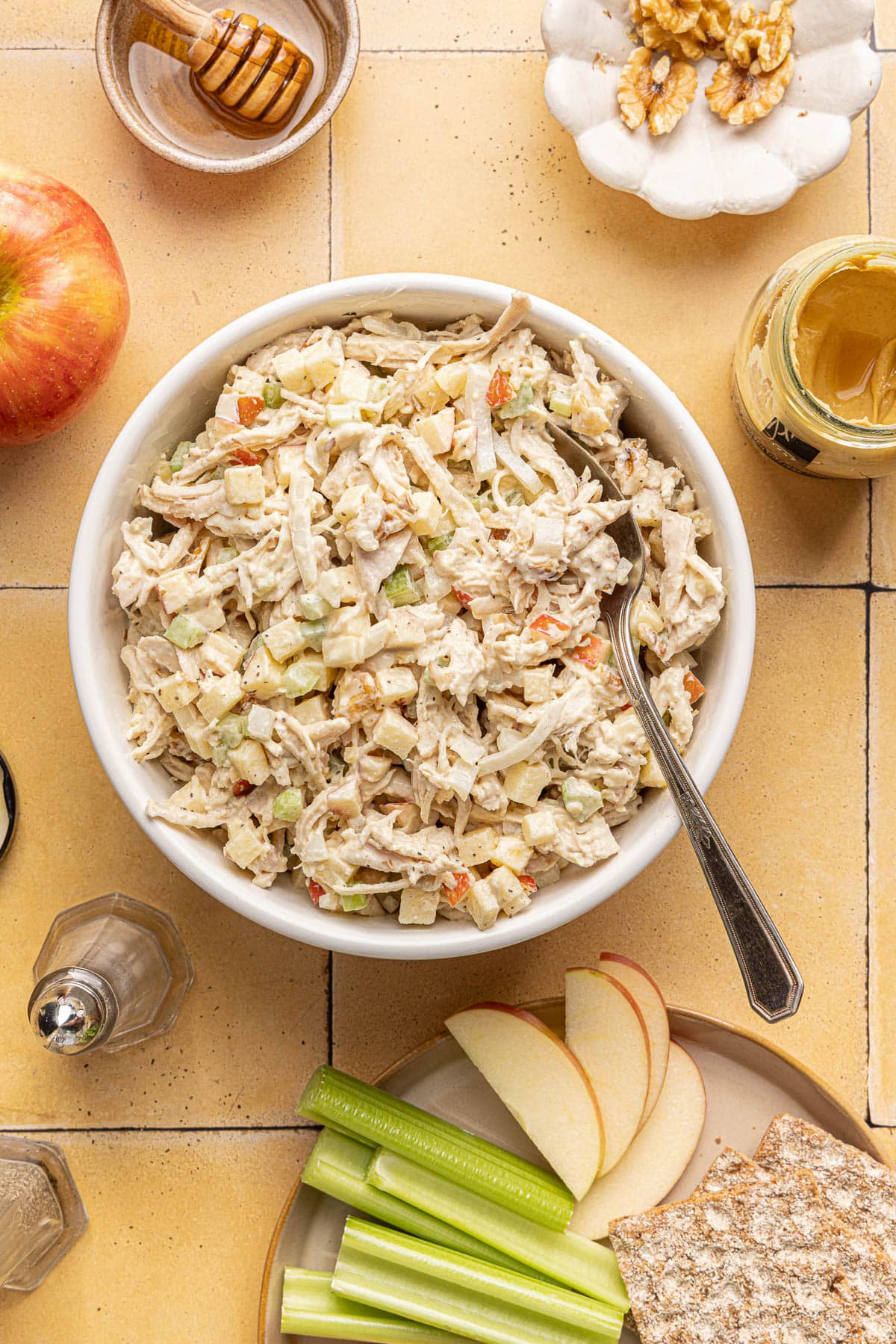 Honey mustard chicken salad in a bowl with a spoon in it on a countertop.