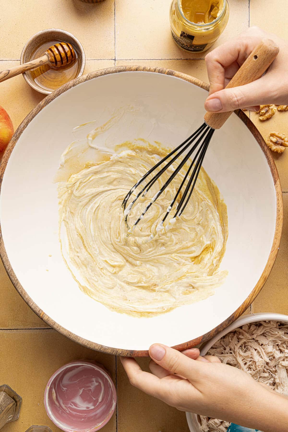 The honey mustard dressing in a bowl while whisking.