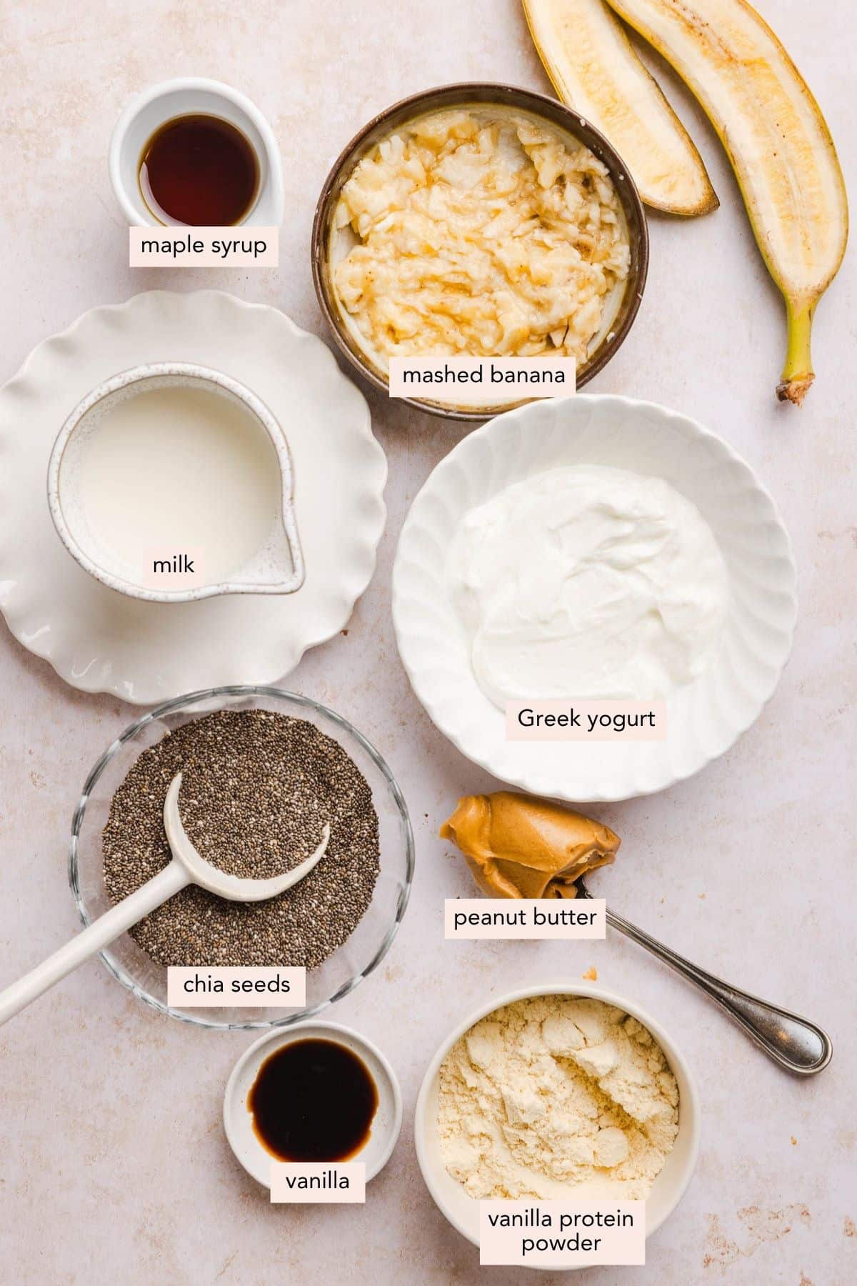 All of the ingredients for peanut butter banana chia pudding in bowls on a countertop.