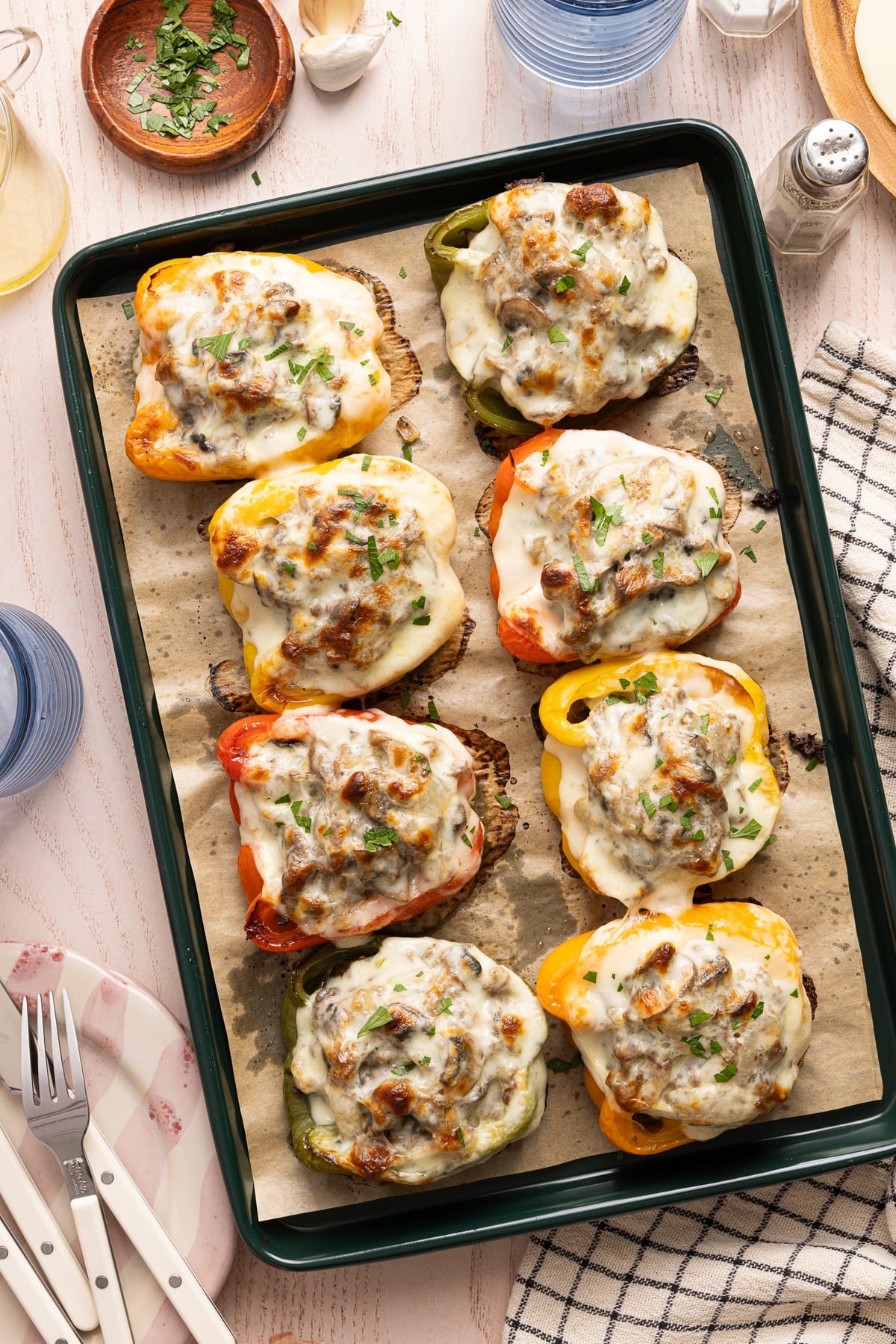The cooked philly cheesesteak stuffed peppers on the parchment paper on the sheet pan after baking.