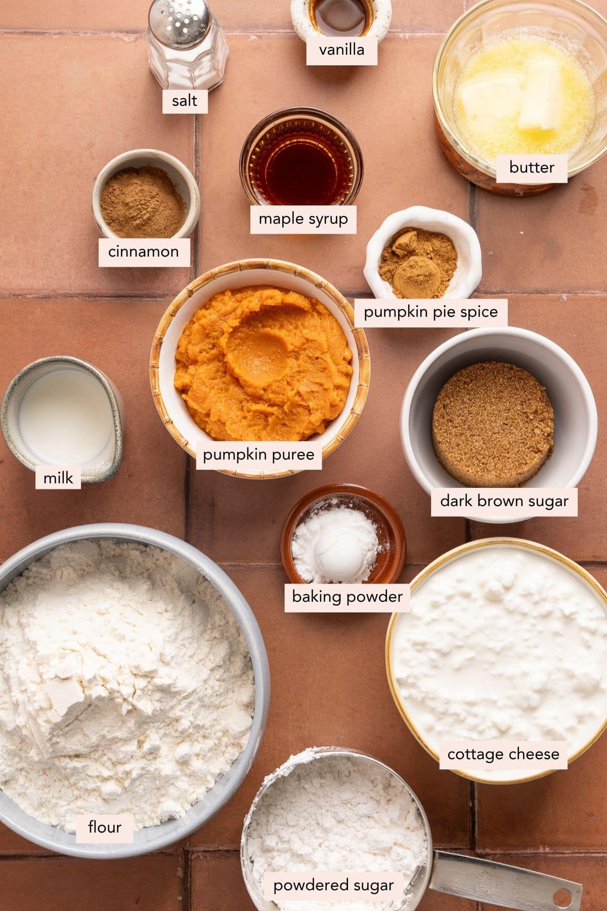 All of the ingredients for pumpkin cinnamon rolls in bowls on a countertop.