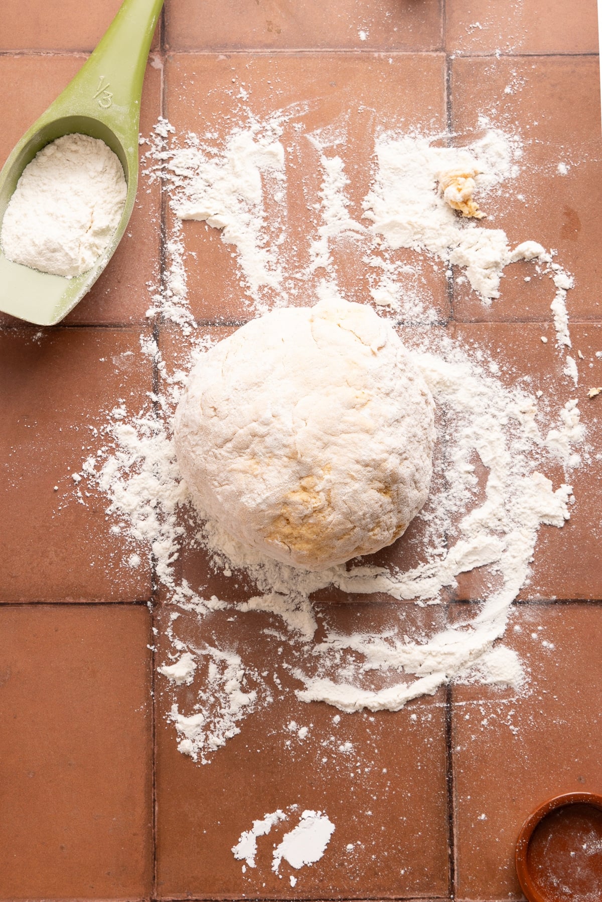 The dough ball on a floured countertop.