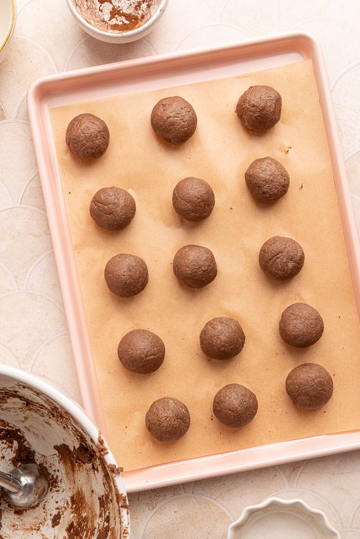 The shaped cottage cheese truffles on a piece of parchment paper on a baking sheet.