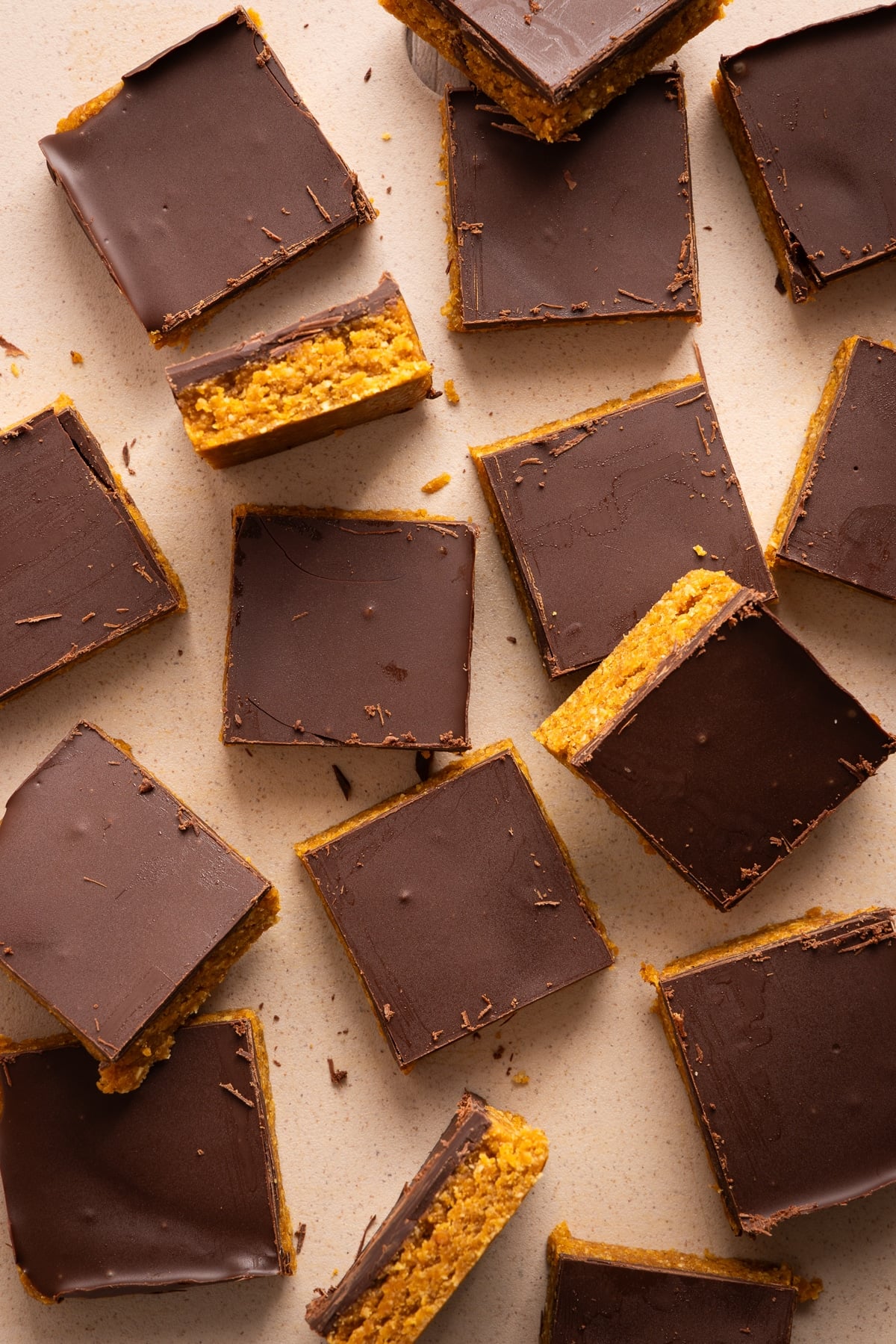 No bake chocolate peanut butter oatmeal bars sliced on a countertop with a few pieces turned sideways do you can see the pumpkin oat layer.