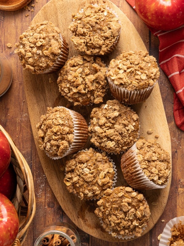 Apple cinnamon muffins on a wooden cutting board after baking.