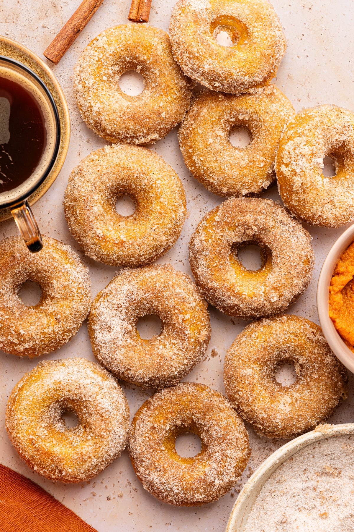 A dozen cottage cheese pumpkin donuts on a countertop.