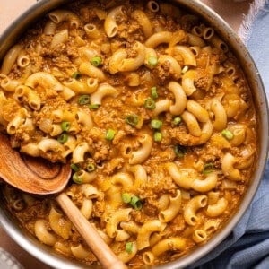 A wooden spoon rests in a pan of healthy hamburger helper.