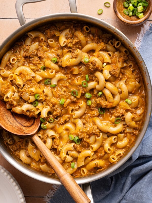 A wooden spoon rests in a pan of healthy hamburger helper.