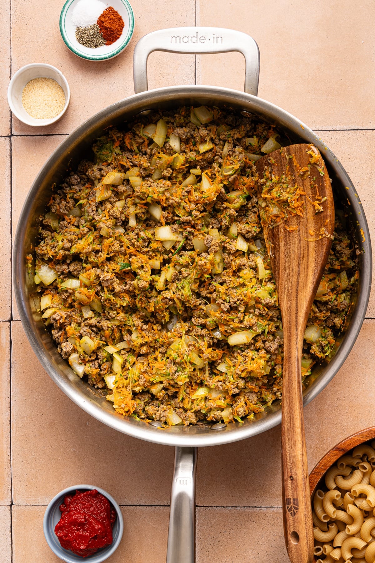 The browned beef mixed together with the shredded veggies in the skillet.