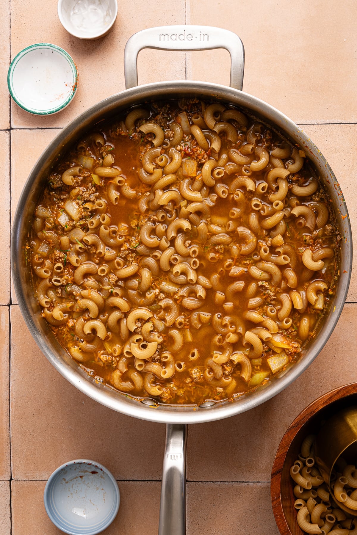 The pasta cooking in the skillet with the other ingredients.