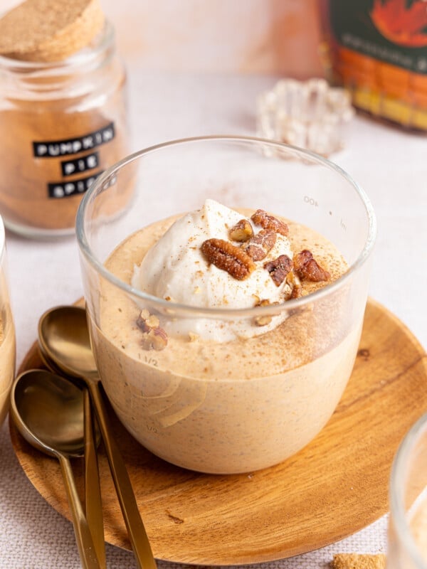 Pumpkin chia pudding in a glass bowl with with Greek yogurt, pecans, and crushed graham crackers.