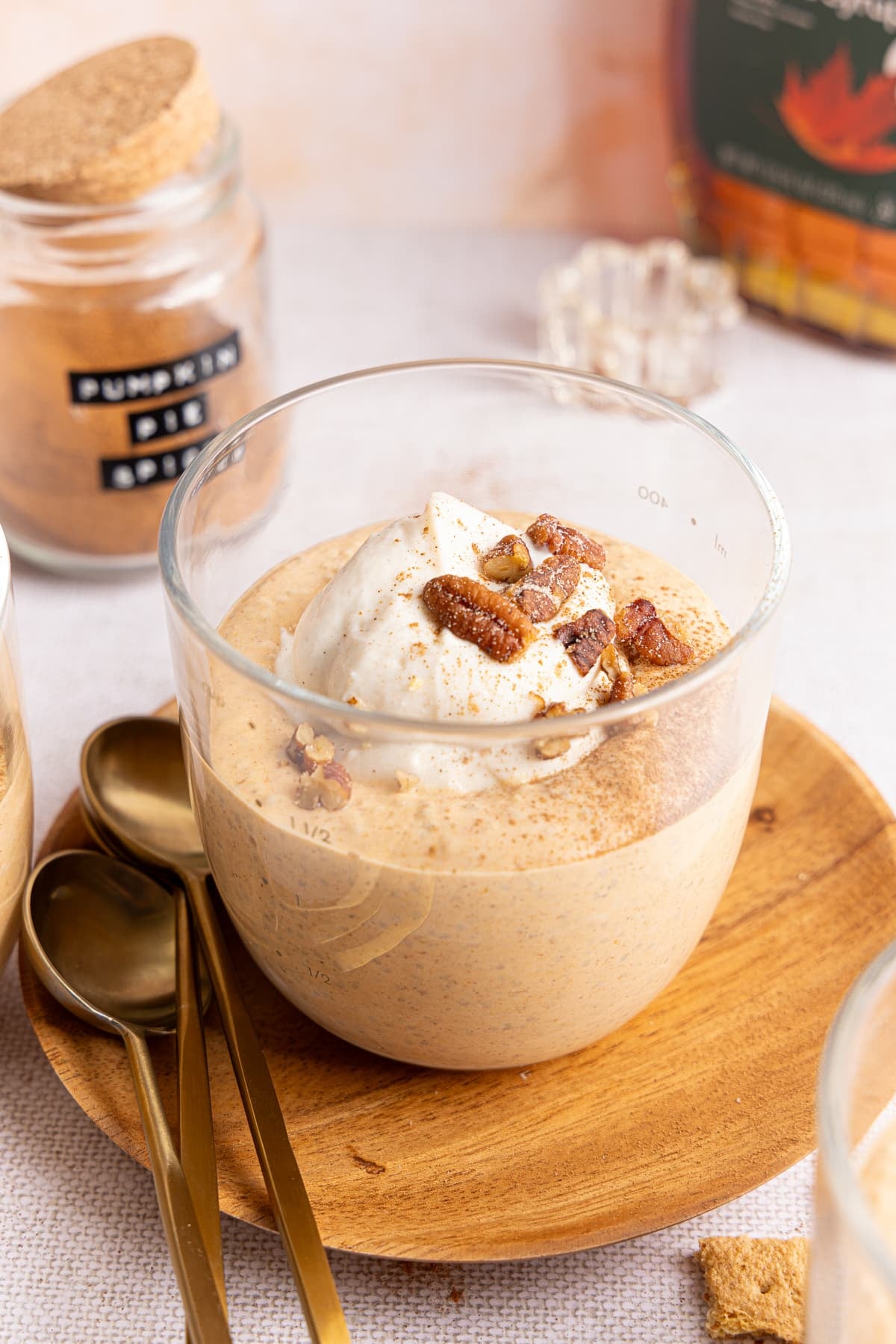 Pumpkin chia pudding in a glass bowl with with Greek yogurt, pecans, and crushed graham crackers.