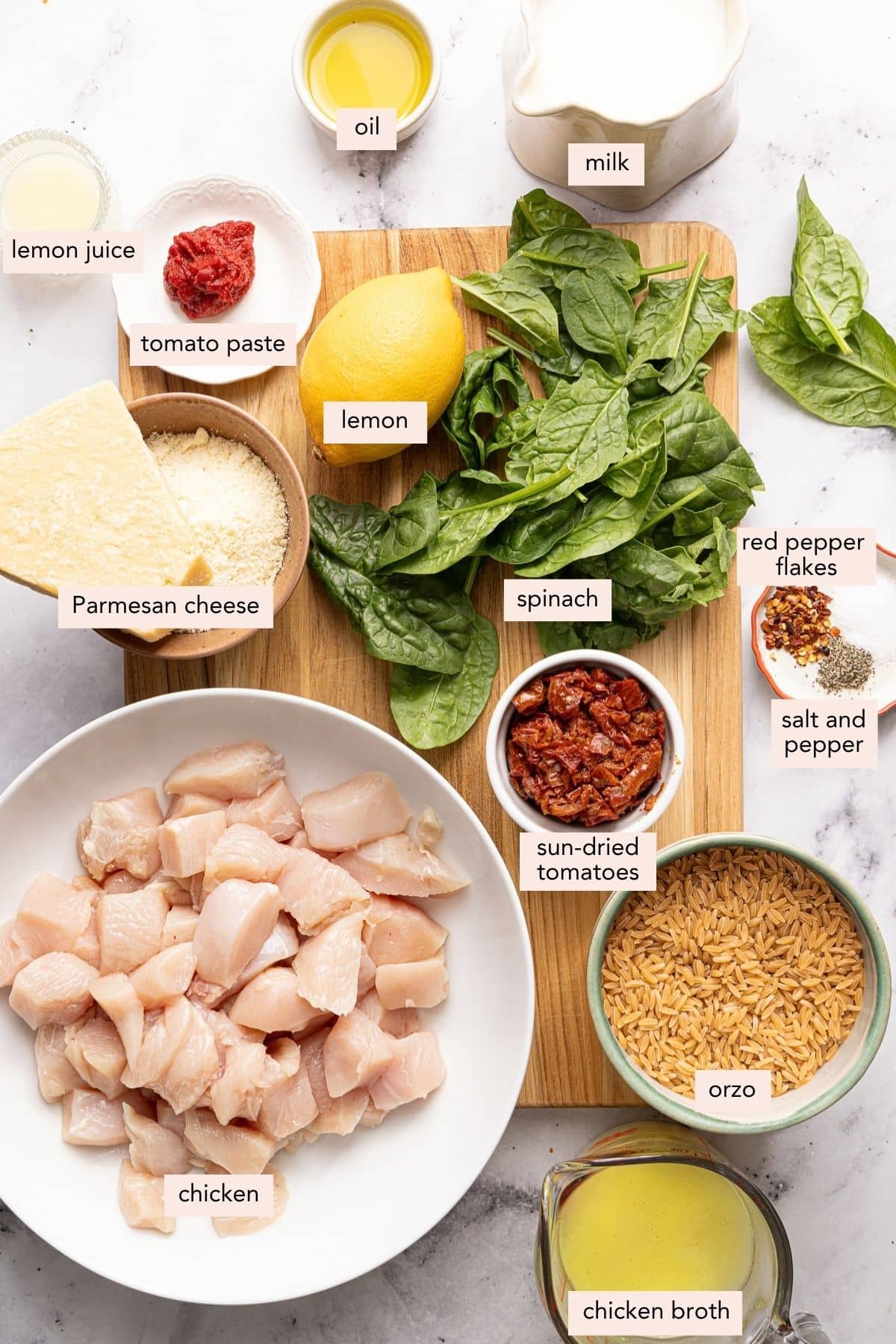 All of the ingredients for marry me chicken orzo in bowls on a countertop.