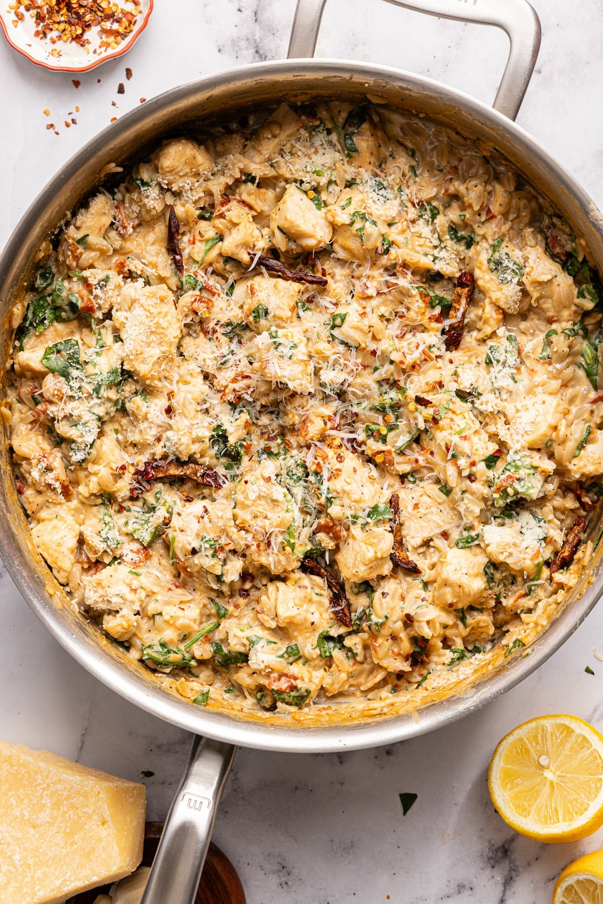 One Pan Marry me chicken orzo in a skillet on a countertop.
