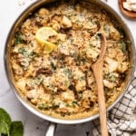 A wooden spoon scoops from the pan of Marry Me Chicken Orzo.