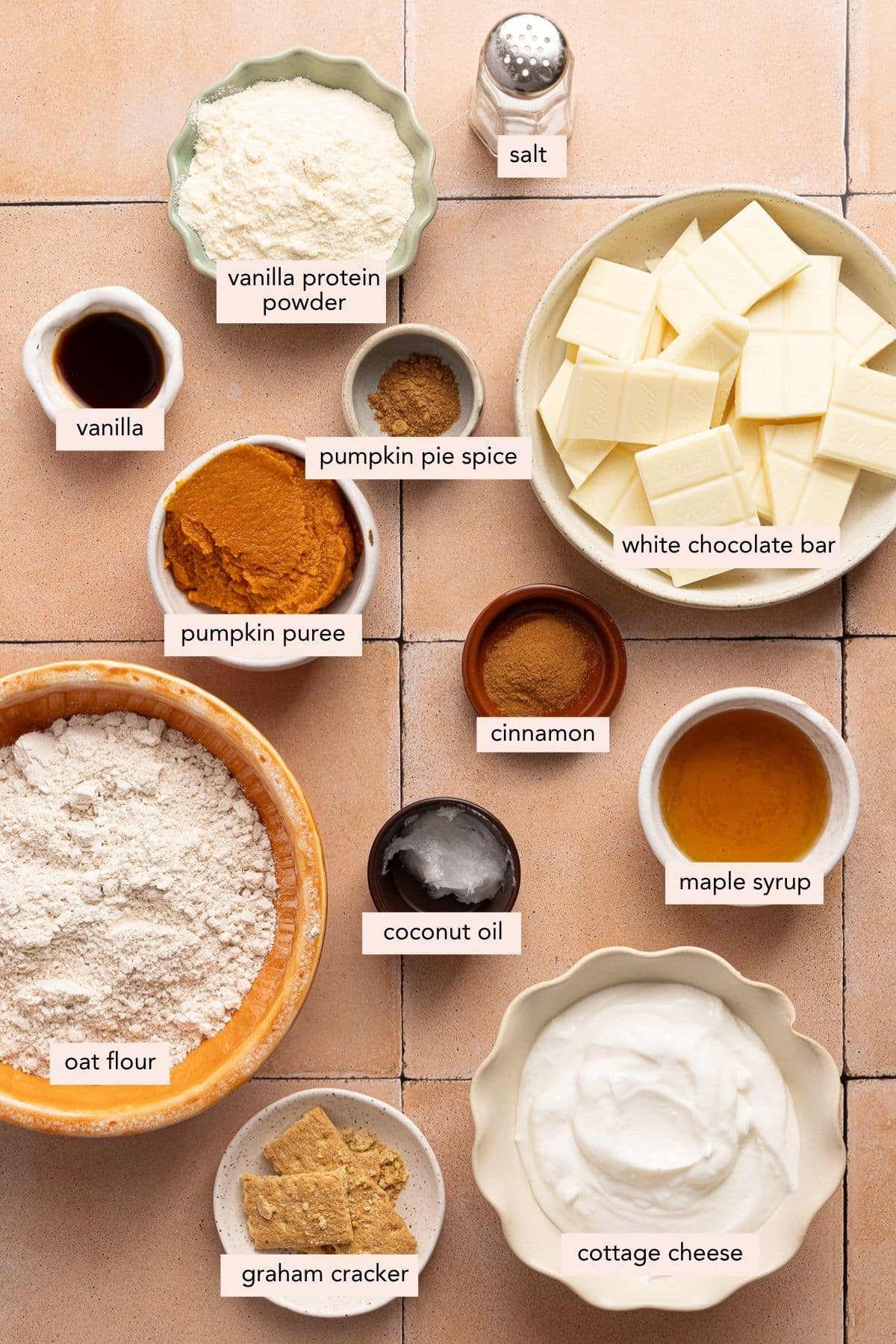All of the ingredients for high protein pumpkin truffles in bowls on a countertop.