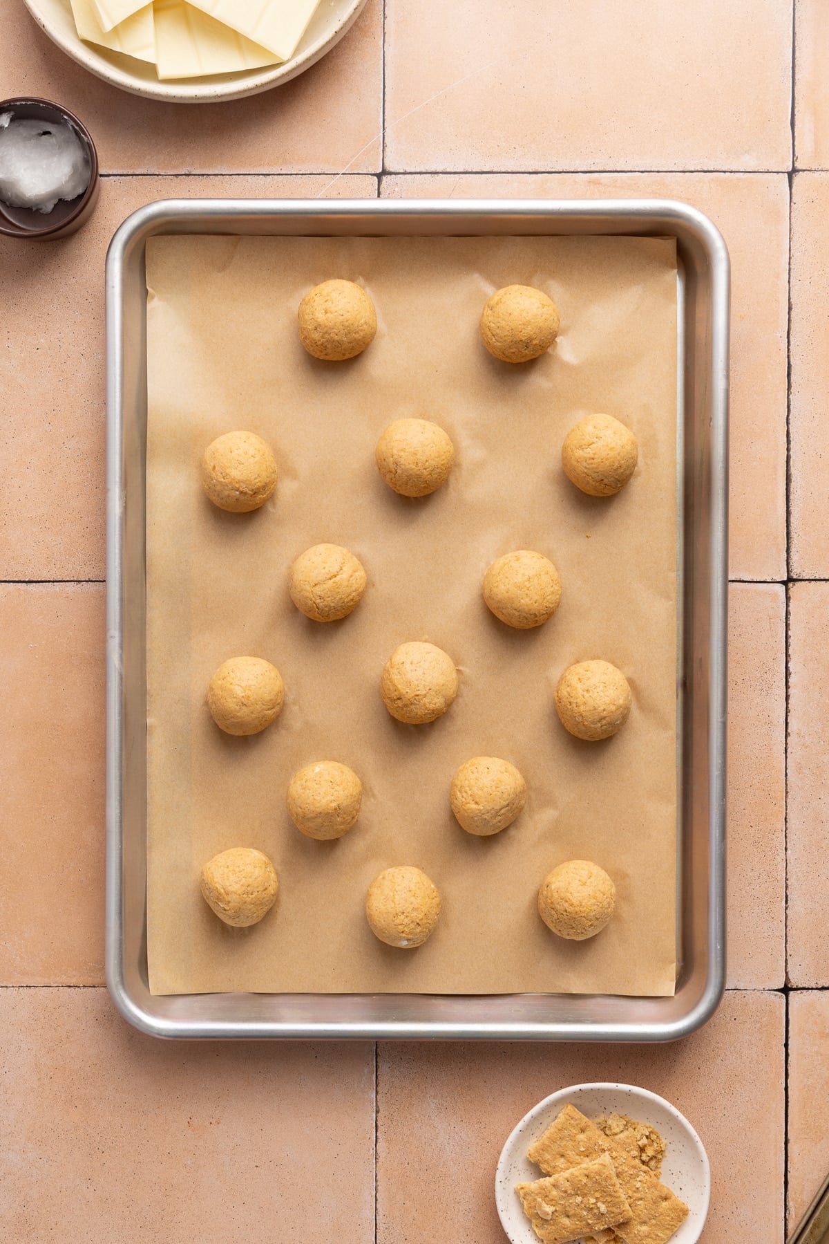 The pumpkin mixture rolled into dough balls on a lined sheet pan.