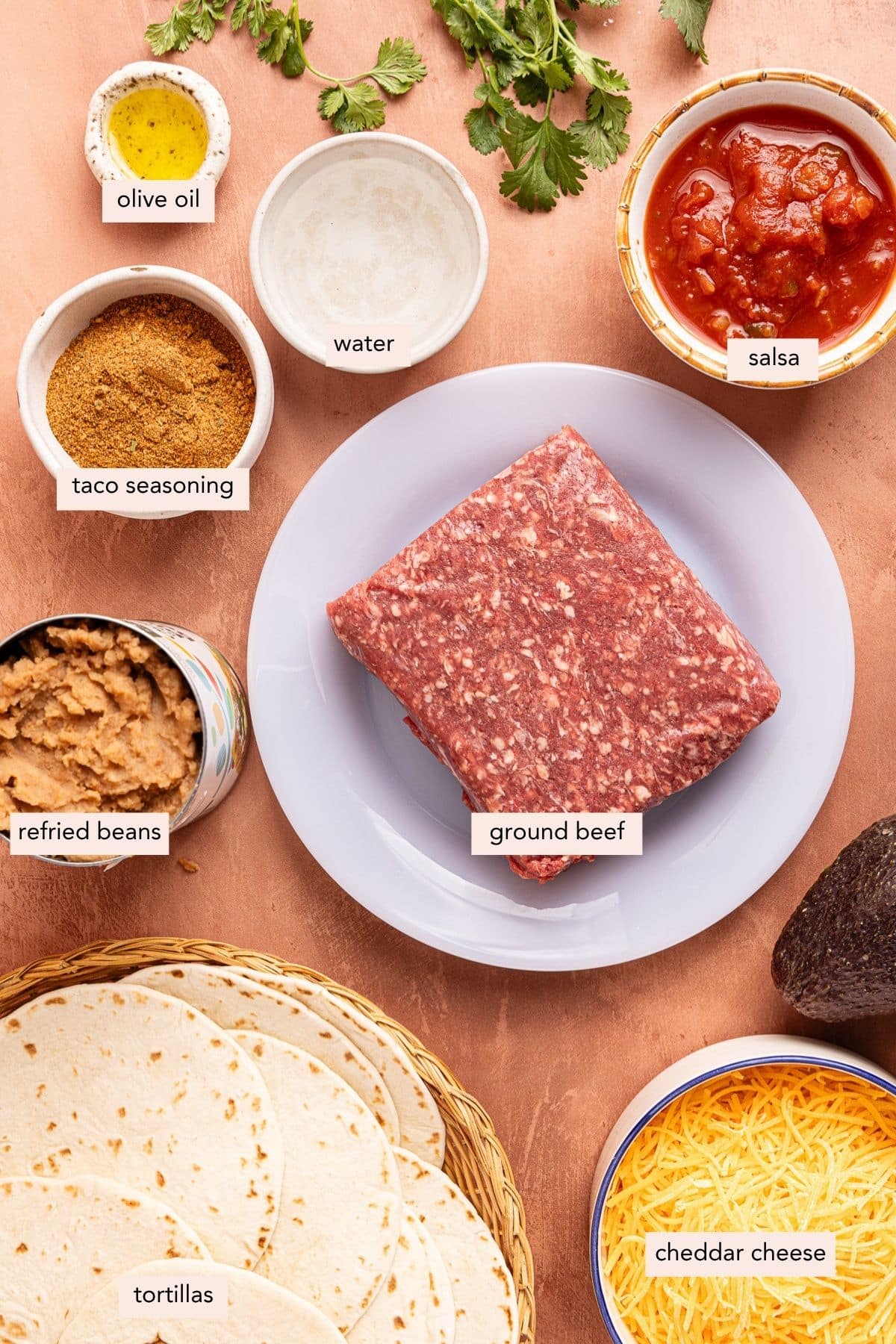 All of the ingredients for sheet pan tacos in bowls on a countertop.